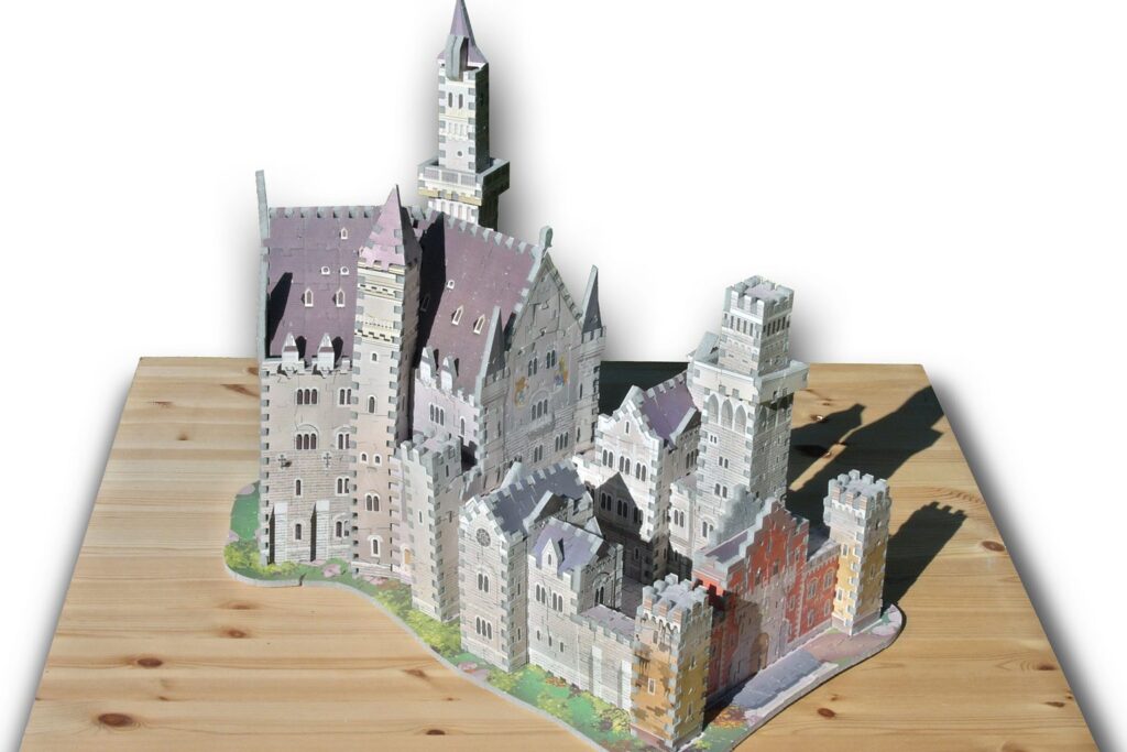 Fertig gebautes 3D-Puzzle von Schloss Neuschwanstein auf einer Holzplatte
