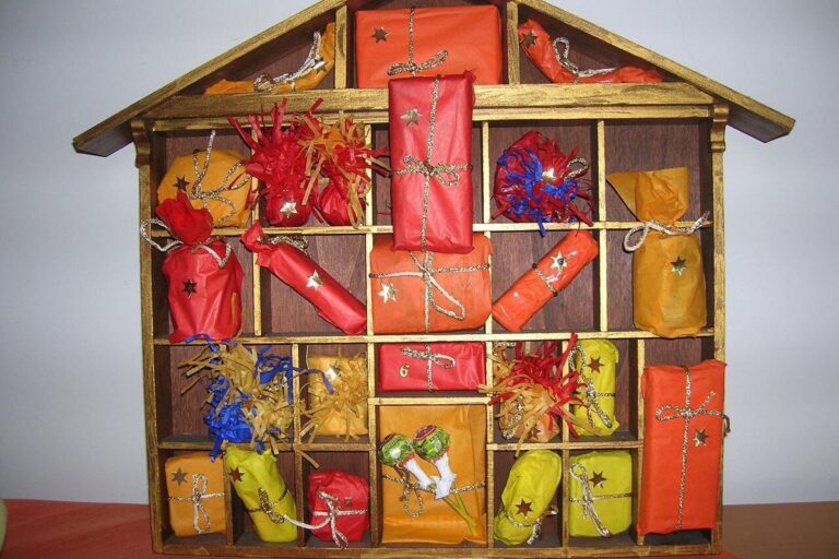 Adventskalender in Form eines Holzhauses mit vielen kleinen, bunt verpackten Päckchen