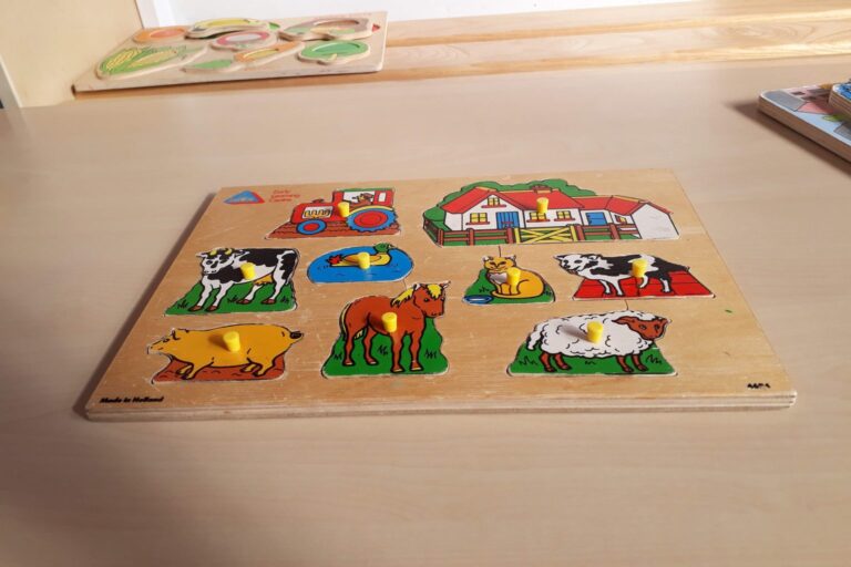 Holz-Steckpuzzle mit bunten Bauernhoftieren auf einem Tisch