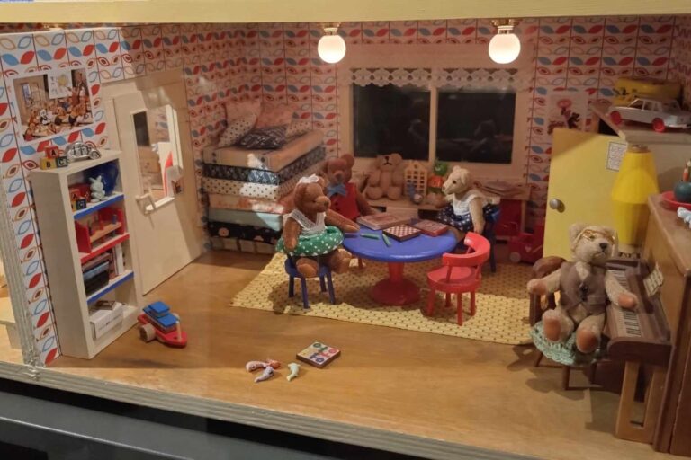 Detailreiches Miniaturzimmer mit Möbeln, Bildern und kleinen Figuren